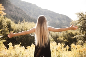Standing Woman in Black Dress Facing Mountain, carefree stress relief